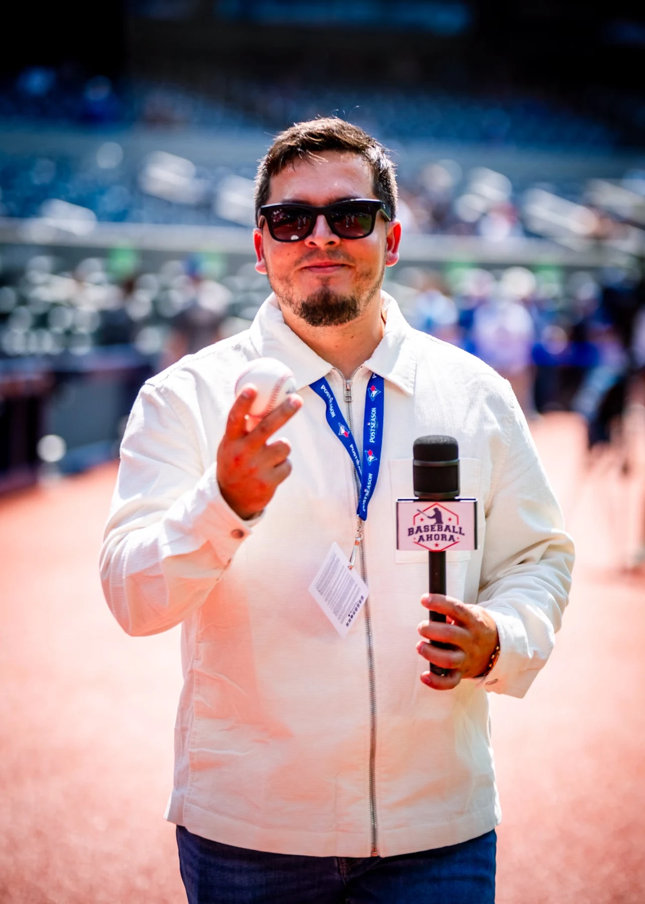 Retrato con pelota de béisbol y micrófono en el estadio